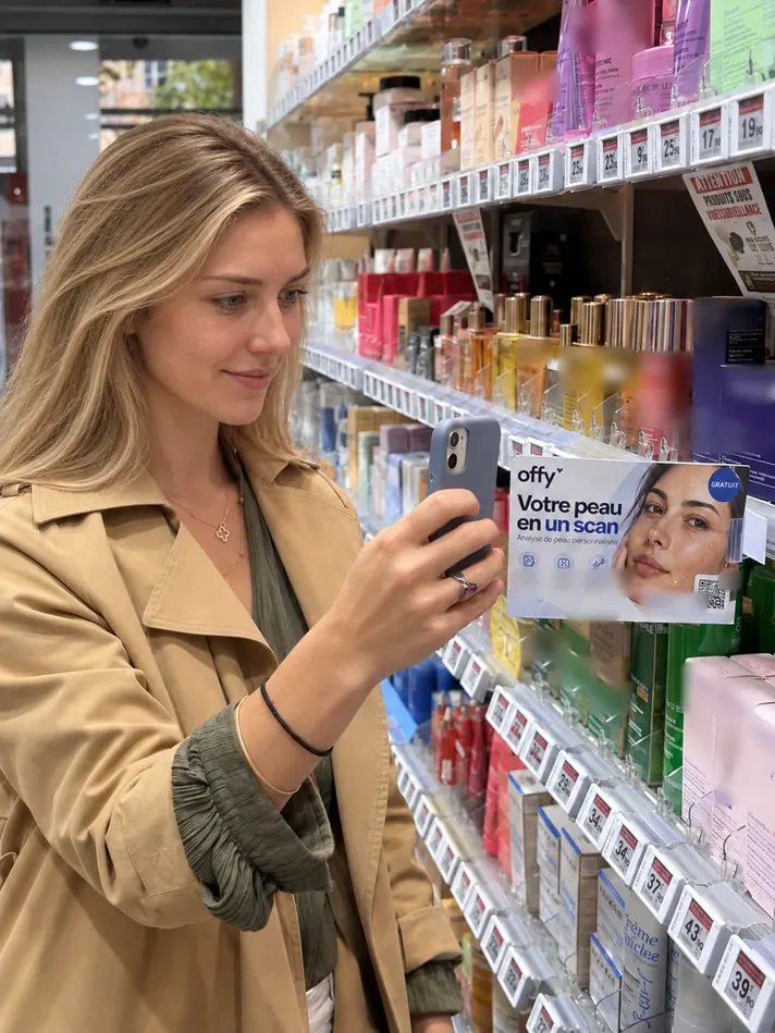 Une cliente scanne le QR code OFFY avec son smartphone, en rayon de pharmacie